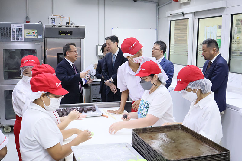 The delegation explored the APCD projects and took a group photo with APCD staff at APCD 60+ Plus Bakery & Chocolate Café.